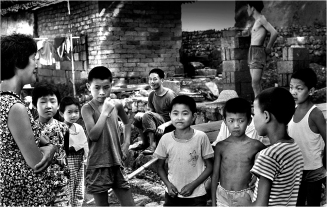 #120-043 Boys and girls generally did not play together. These are all boys. In the rivers, only the boys swam. Both were friendly, inquisitive and had no problems with having their picture taken. The summer is hot in China’s continental climate and there was no air conditioning in 1979. Kids stripped down to the bare minimum to keep cool. Of course where there was any swimmable place the kids swam but I never came across a public swimming pool anywhere in those days. In 1979, lots of people moved bamboo beds out on to the sidewalk at night and slept there because their dwellings were just too darned hot.