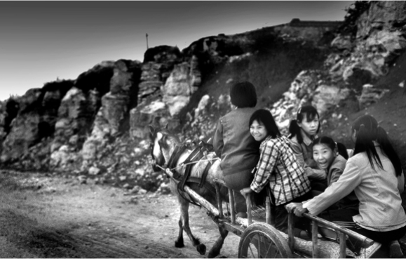 #204-003 In 1979, people in northern Shaanxi Province were still living in caves. In the countryside, one-cylinder tractors converted to mini-trucks were slowly replacing pony carts that have been in use for over 2000 years. For hundreds of years, the combination of China’s government policies and the extreme and vast remoteness of the country made a white foreigner a rare visitor. These girls are surprised to see a foreigner and greeted me with amusement and puzzlement. But when I spoke out in fluent Chinese there was a warm response and hospitality.